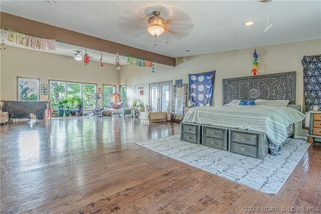 bedroom featuring hardwood / wood-style floors, ceiling fan, and beam ceiling