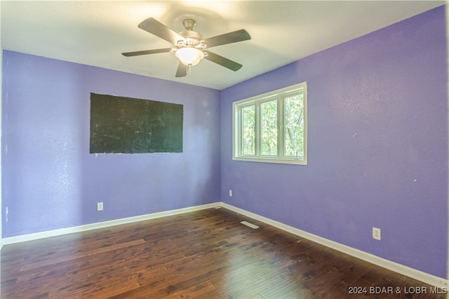 spare room with ceiling fan and dark hardwood / wood-style flooring