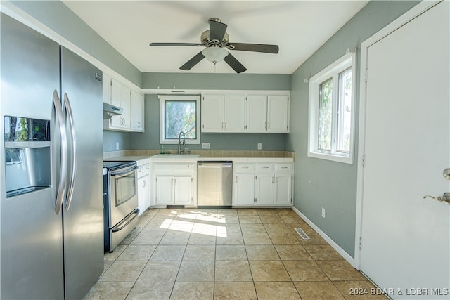 kitchen featuring ceiling fan, white cabinetry, stainless steel appliances, and light tile patterned floors