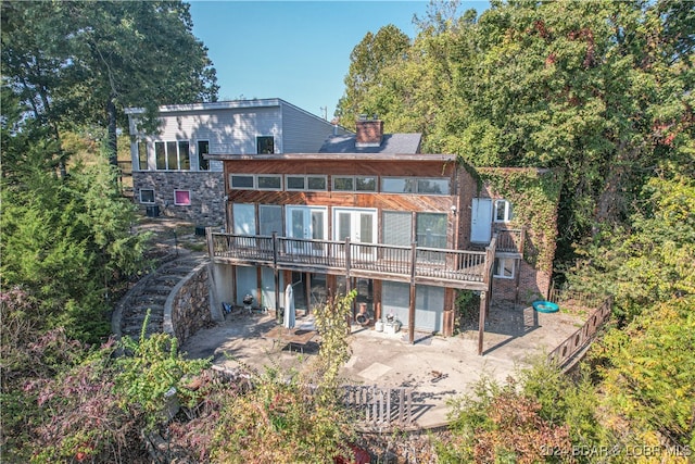 back of house with a wooden deck and a patio area