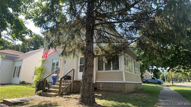 view of front of house featuring entry steps and a front yard