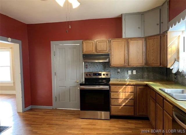 kitchen with ceiling fan, light hardwood / wood-style flooring, tasteful backsplash, sink, and stainless steel appliances