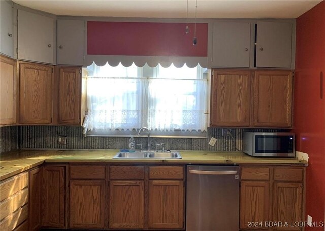 kitchen featuring appliances with stainless steel finishes, decorative backsplash, and sink