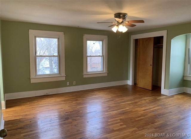 unfurnished bedroom with ceiling fan, a closet, and wood-type flooring