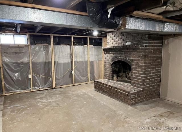 basement featuring brick wall and a brick fireplace