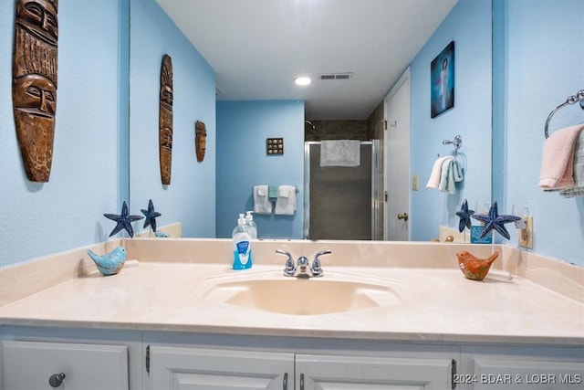 bathroom featuring vanity and a shower with door