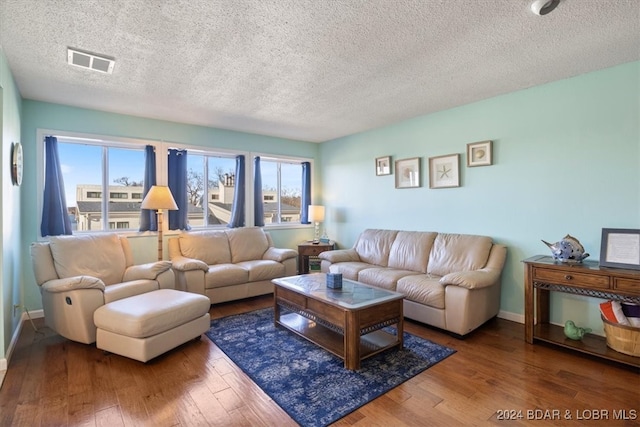 living room with wood-type flooring and a textured ceiling