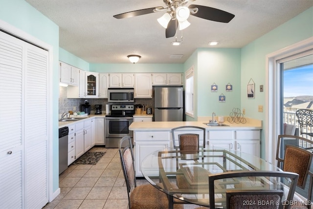 kitchen with stove, light tile patterned floors, backsplash, refrigerator, and dishwashing machine