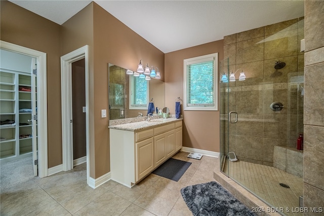 bathroom with tile patterned floors, vanity, walk in shower, and an inviting chandelier