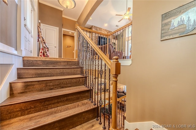 stairs with ceiling fan, hardwood / wood-style flooring, and crown molding