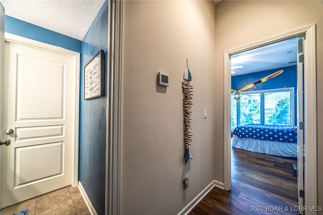 hallway with hardwood / wood-style flooring and a textured ceiling