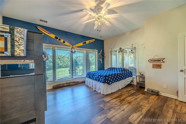 bedroom featuring ceiling fan, multiple windows, and hardwood / wood-style flooring