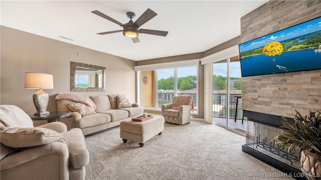 living room featuring a multi sided fireplace, light colored carpet, and ceiling fan