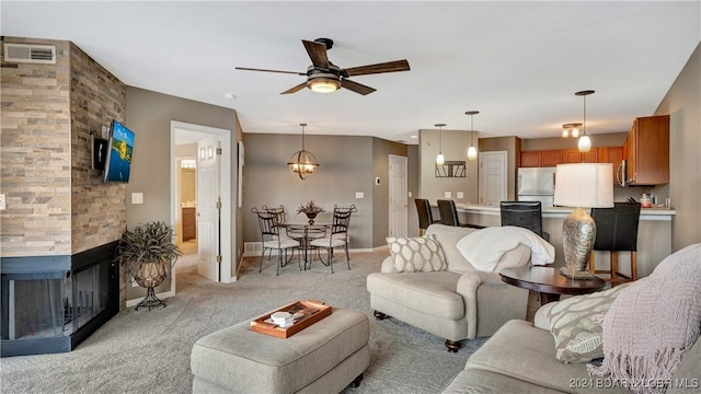 329 Bristol Bay Dr Unit 3B, Lake Ozark, MO 65049 - living area featuring light colored carpet, a ceiling fan, a multi sided fireplace, and baseboards