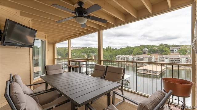 balcony with ceiling fan and a water view