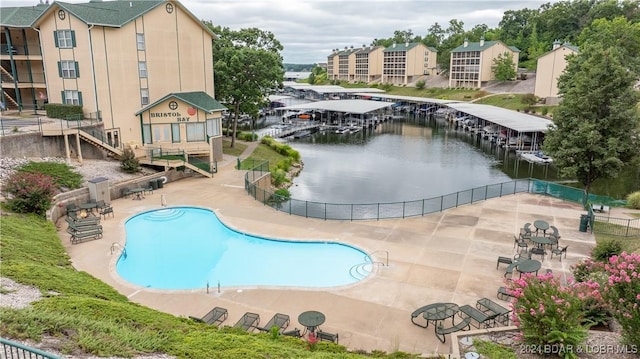 view of swimming pool featuring a water view and a patio area