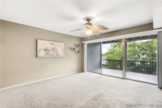 carpeted empty room with ceiling fan and a textured ceiling