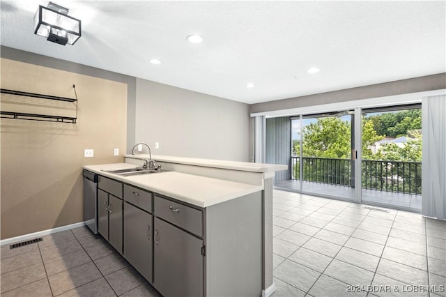 kitchen with gray cabinetry, dishwasher, sink, light tile patterned floors, and kitchen peninsula