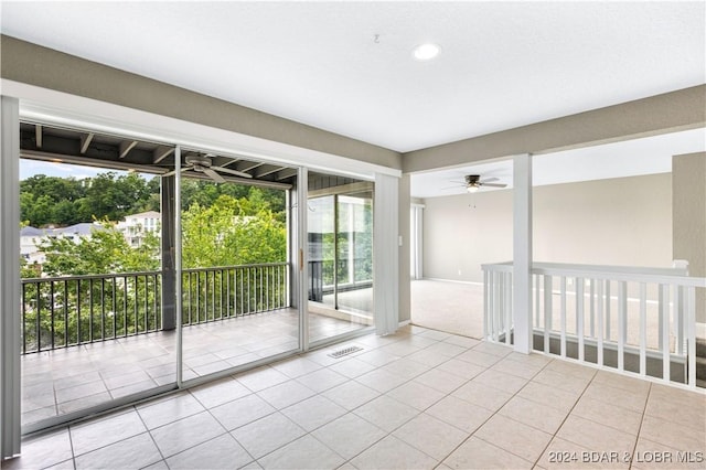 tiled empty room featuring ceiling fan