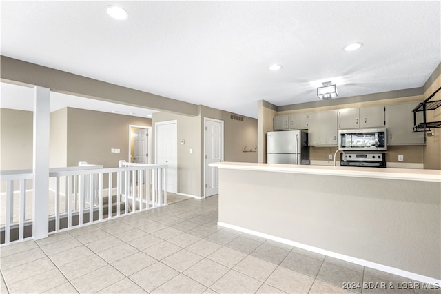 kitchen featuring decorative backsplash, appliances with stainless steel finishes, gray cabinets, and light tile patterned floors