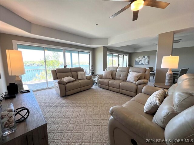 carpeted living room with ceiling fan