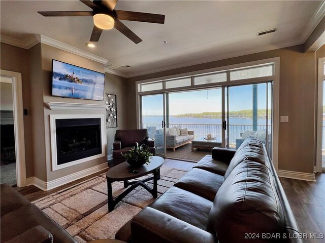 living room with ceiling fan, a healthy amount of sunlight, crown molding, and hardwood / wood-style flooring