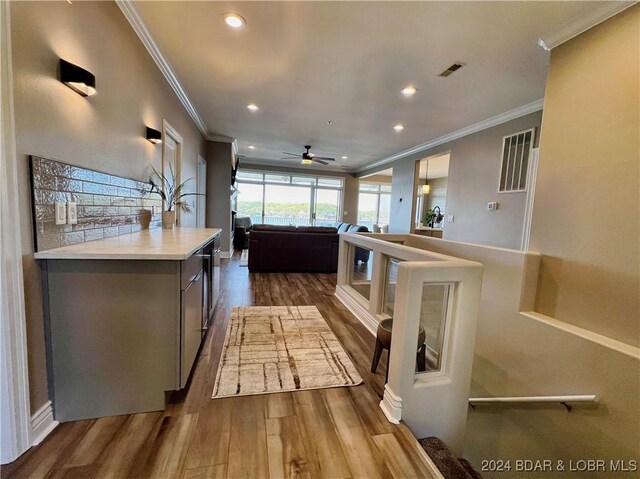 kitchen featuring ceiling fan, crown molding, and hardwood / wood-style flooring