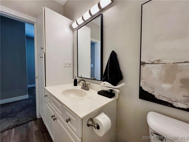 bathroom featuring toilet, hardwood / wood-style flooring, and vanity