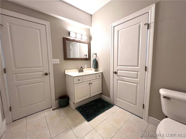 bathroom with tile patterned flooring, toilet, and vanity