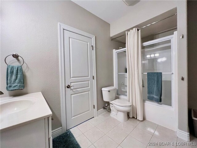 full bathroom featuring tile patterned floors, vanity, shower / bath combination with glass door, and toilet