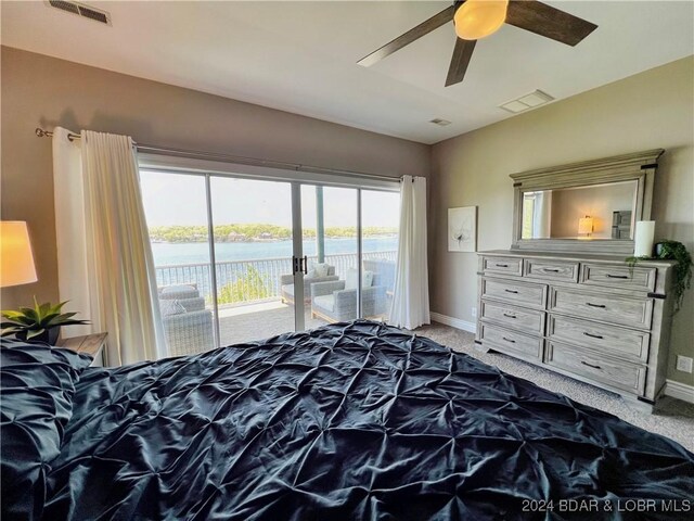 bedroom with ceiling fan, a water view, access to outside, and carpet