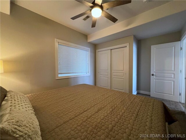 carpeted bedroom with ceiling fan and a closet