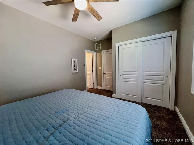 bedroom with ceiling fan, carpet, and a closet