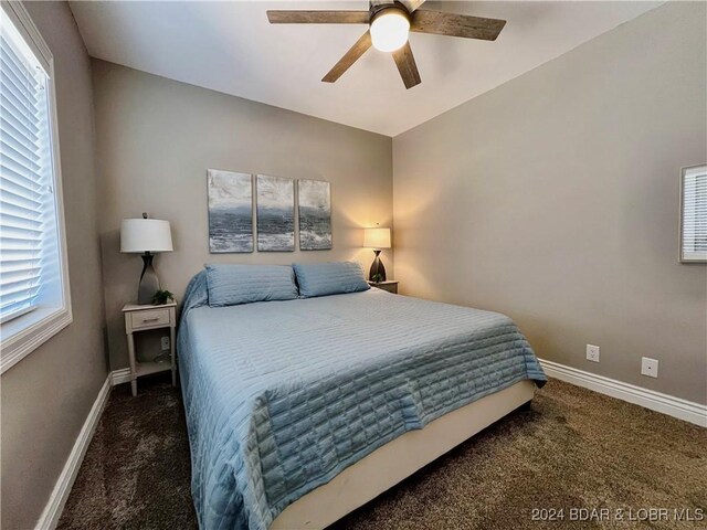 carpeted bedroom with ceiling fan and multiple windows