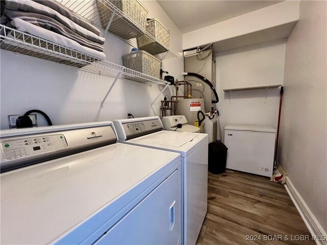 laundry area with water heater, dark hardwood / wood-style floors, and separate washer and dryer