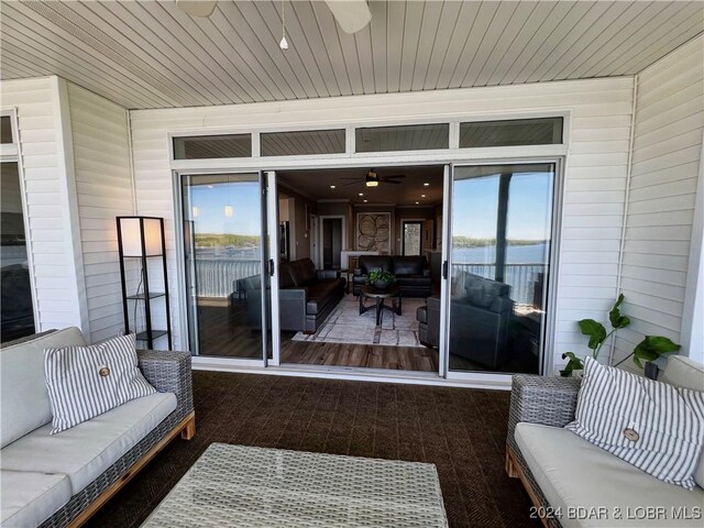 exterior space featuring ceiling fan, an outdoor living space, and a water view