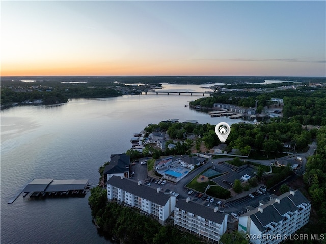 aerial view at dusk featuring a water view