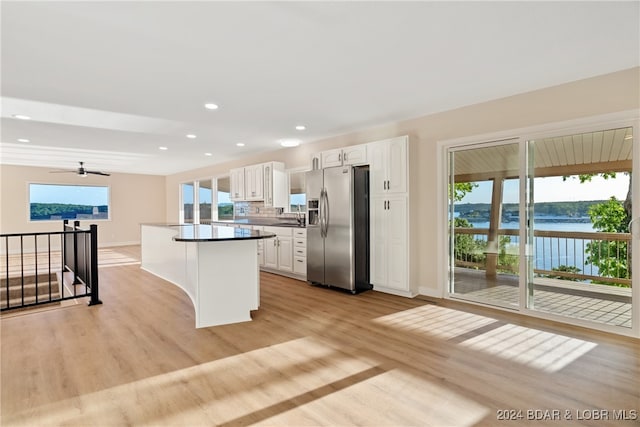 kitchen with a water view, light hardwood / wood-style floors, white cabinetry, and stainless steel refrigerator with ice dispenser