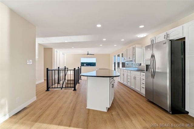 kitchen featuring white cabinets, a center island, light wood-type flooring, and stainless steel fridge with ice dispenser