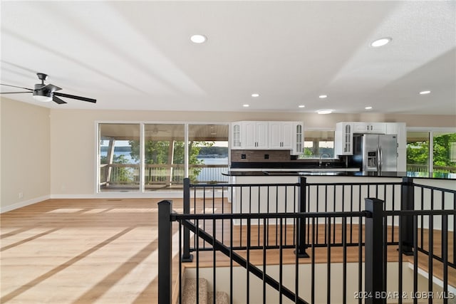 kitchen with a wealth of natural light, stainless steel fridge, and white cabinetry