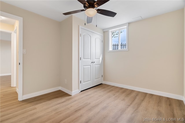 unfurnished bedroom with light hardwood / wood-style flooring, a closet, and ceiling fan