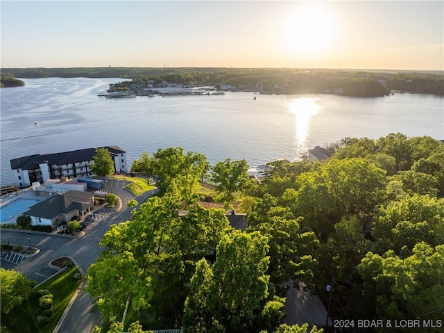 aerial view at dusk featuring a water view