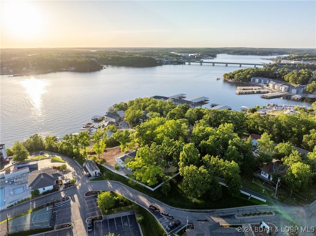 aerial view at dusk featuring a water view