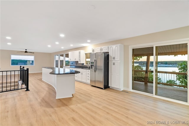 kitchen featuring white cabinetry, light hardwood / wood-style floors, a water view, and stainless steel fridge with ice dispenser