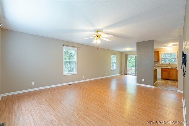 unfurnished living room with a healthy amount of sunlight, light hardwood / wood-style flooring, sink, and ceiling fan