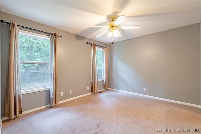 carpeted spare room featuring ceiling fan