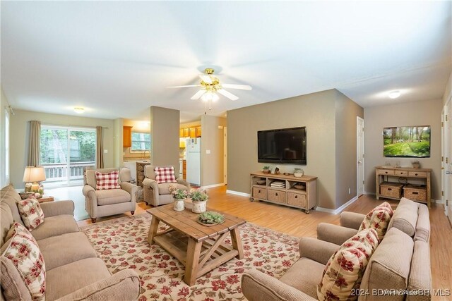 living room featuring light hardwood / wood-style flooring and ceiling fan