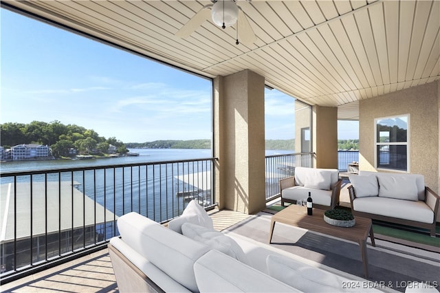 balcony with ceiling fan, an outdoor hangout area, and a water view