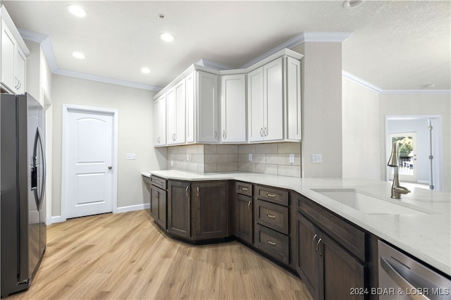 kitchen featuring stainless steel appliances, light hardwood / wood-style flooring, decorative backsplash, sink, and white cabinets