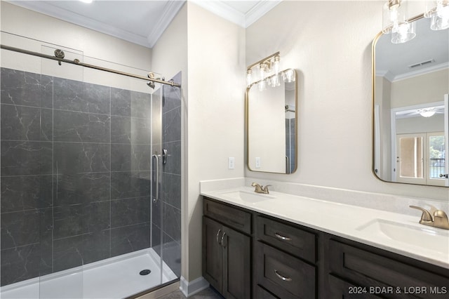 bathroom with a shower with door, ceiling fan, ornamental molding, and dual bowl vanity